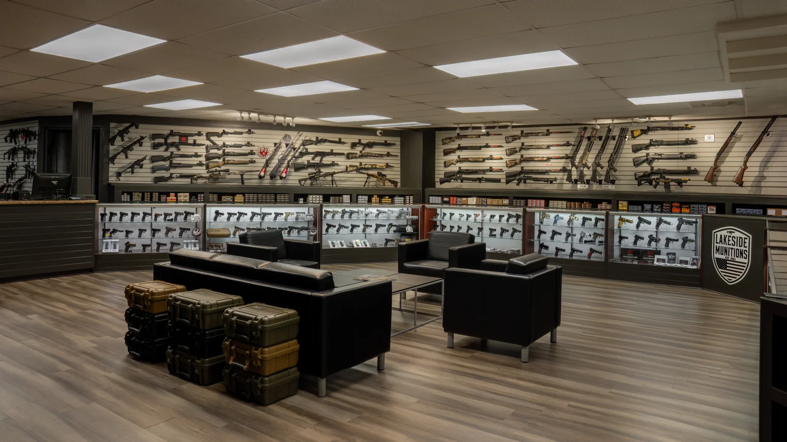 Showroom with black leather seating, stacked hard cases and a Lakeside shield on the wall